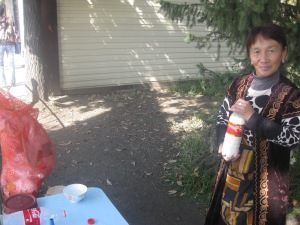 A woman selling kumys (fermented mare's milk) near the central square